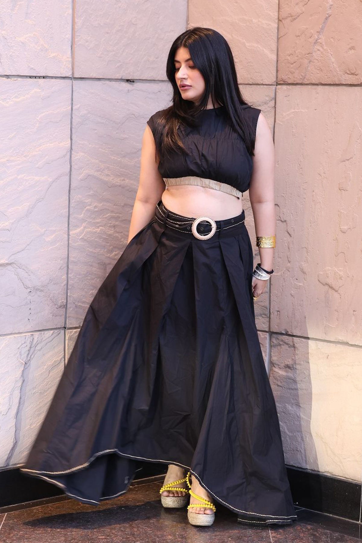 Trishala Sikka in Black poplin asymetrical skirt with chawal taka hemline and belt paired with ruched crop top