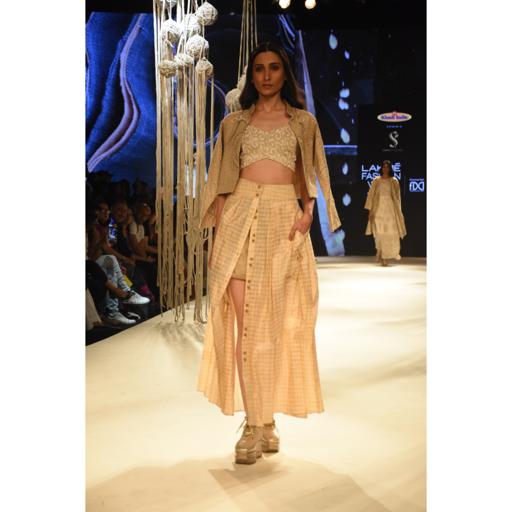 Beige embroidered crop jacket with bustier, beige shorts and front open 3 pleated skirt