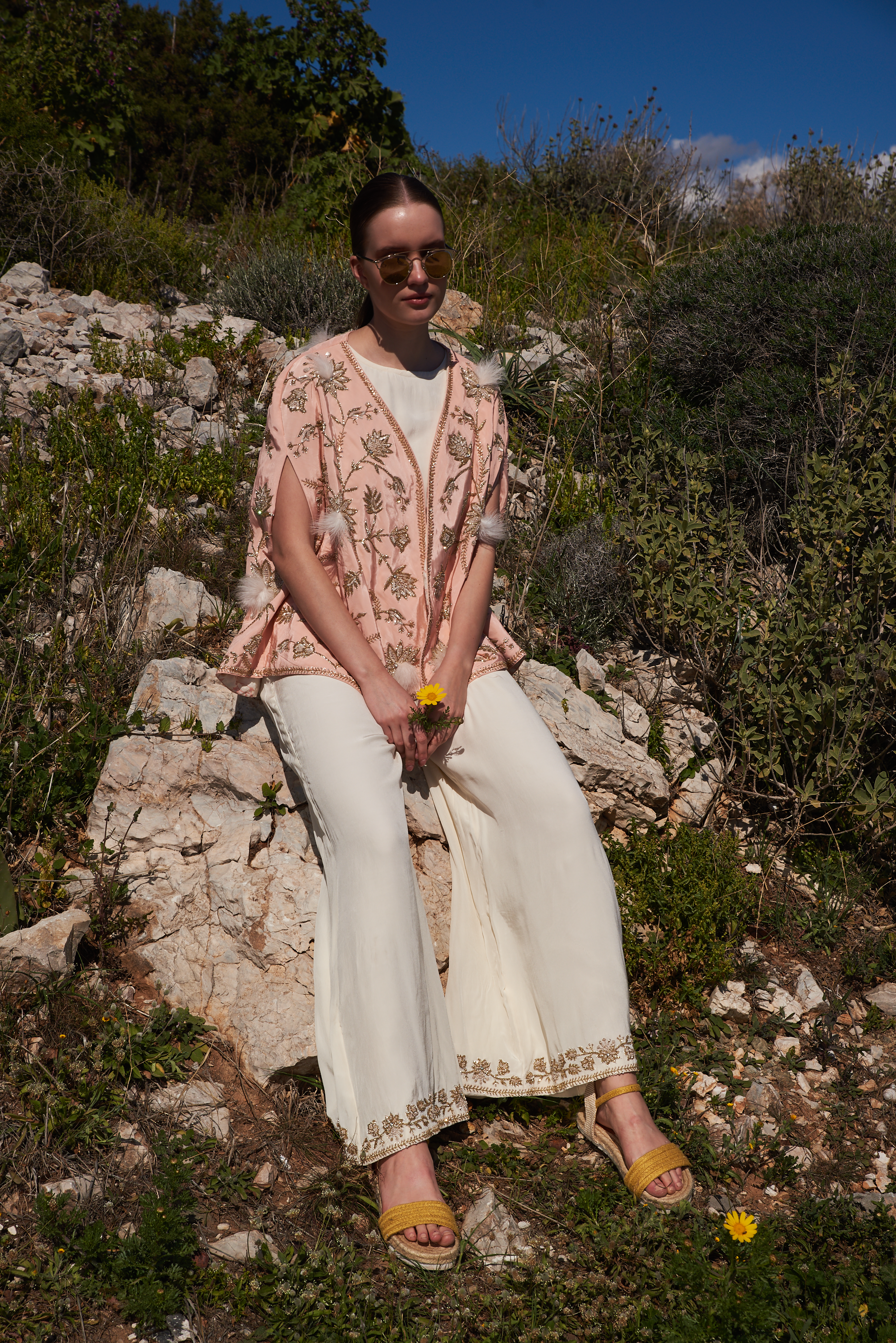 Salmon embroidered cape with feathers and white jumpsuit with embroidery at hem
