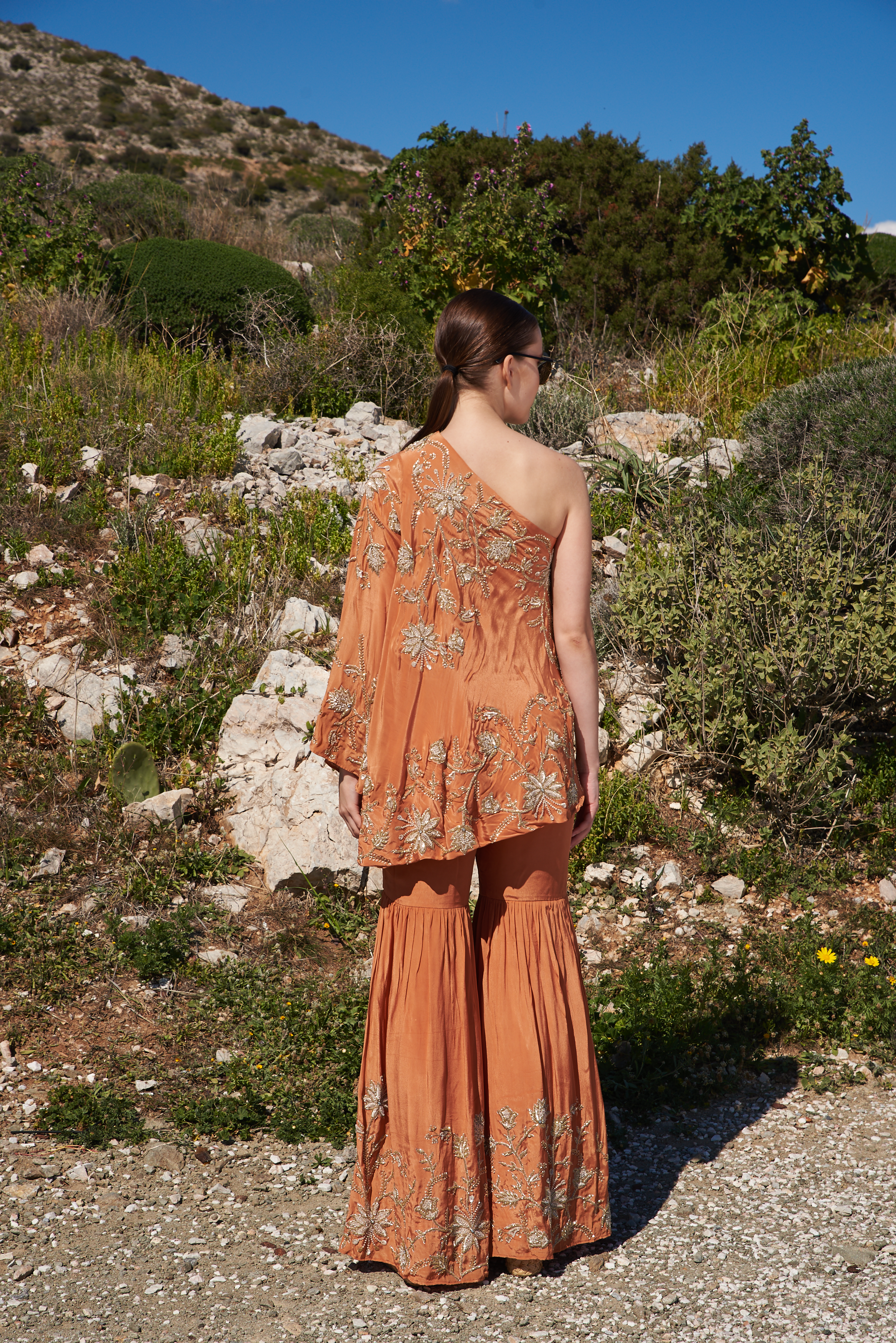 Rust crepe embroidered one off shoulder cape with rust crepe embroidered sharara pants