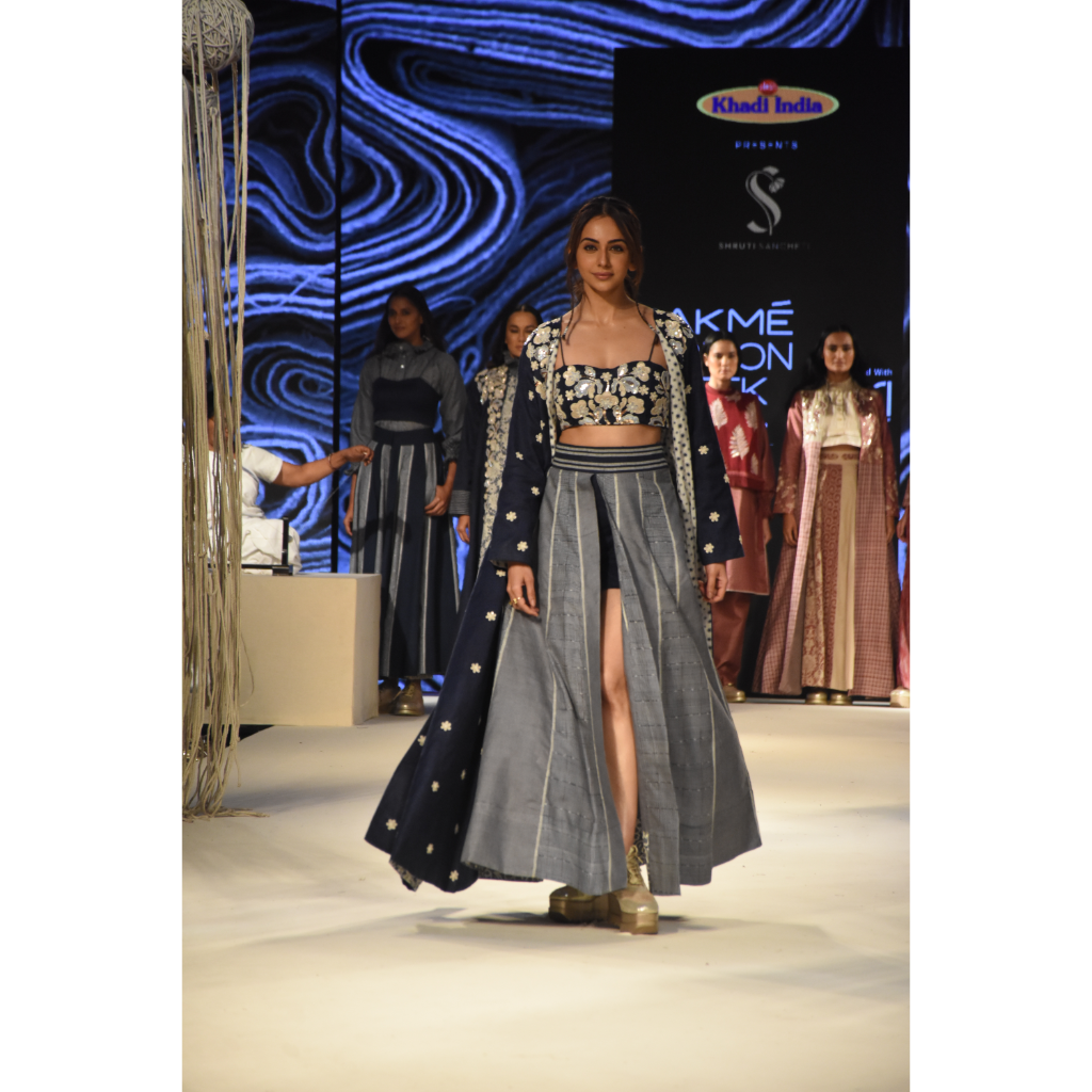 Blue embroidered long jacket with a front open checked kalidar skirt and an attached shorts with embroidered bustier