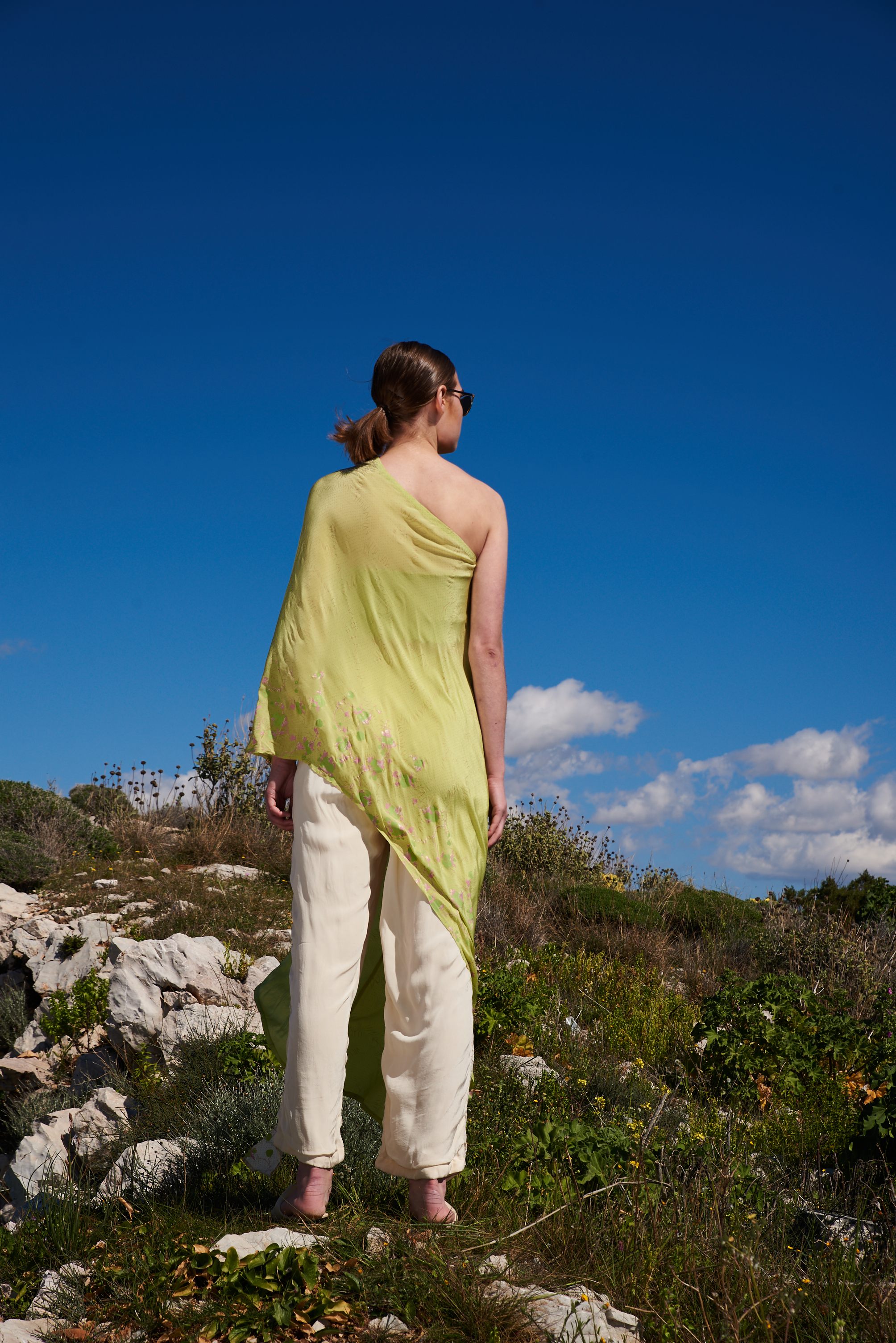 Green crepe printed and embroidered asymmetrical one off shoulder cape with ivory printed flap pants